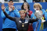 Marcel Hug of Switzerland holds up the trophy after winning the men's wheelchair division of the 119th Boston Marathon in Boston, Massachusetts April 20, 2015. REUTERS/Brian Snyder