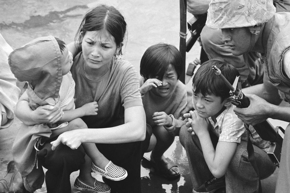 A weeping woman and her three children on a boat.