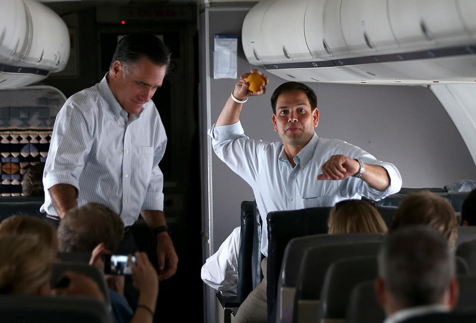 IN FLIGHT, FL - AUGUST 13:  U.S. Sen. Marco Rubio (R-FL) pretends to throw an orange as Republican presidential candidate and former Massachusetts Governor Mitt Romney looks on aboard his campaign plane on August 13, 2012 en route to Miami, Florida. Mitt Romney continues his multi state bus tour after announcing Rep. Paul Ryan (R-WI) as his running mate.  (Photo by Justin Sullivan/Getty Images)
