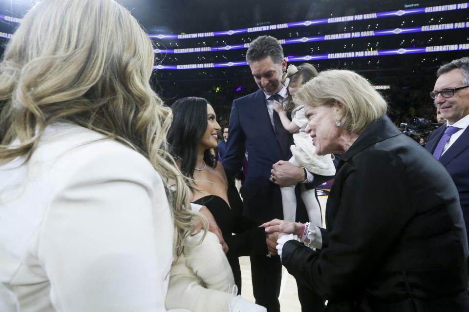 Pau Gasol holds his daughter Elisabet Gianna Gasol while speaking with Vanessa Bryant.