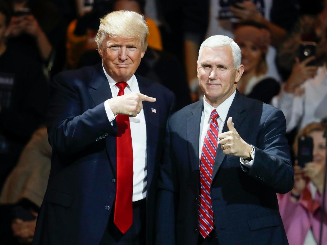 Former President elect Donald Trump, left, and former Vice President Mike Pence acknowledge the crowd during the first stop of his post-election tour, in Cincinnati on December 1, 2016.