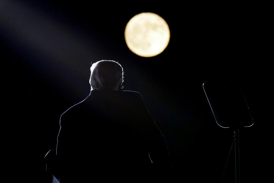 With a full moon in the background, President Donald Trump speaks at a campaign rally at Pittsburgh-Butler Regional Airport, Saturday, Oct. 31, 2020, in Butler, Pa. (AP Photo/Alex Brandon)