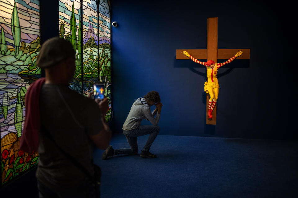 A visitor poses for a photo next to a Jani Leinonen artwork called Mc Jesus, at Barcelona's Museum of Forbidden Art in Barcelona, Spain, Friday, Nov. 17, 2023. In 2019, the Christian community in Haifa demande de removal of Leinonen artwork from the city's museum, considering it offensive. A new museum in Barcelona is offering a second chance to controversial artworks that have suffered censorship for religious, sexual, political or commercial reasons. (AP Photo/Emilio Morenatti)