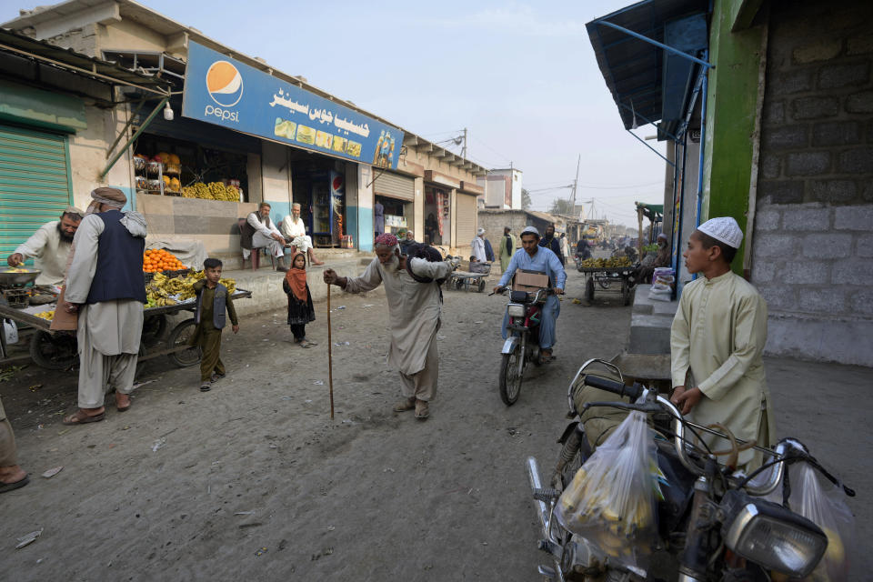 People walk on a street in a a neighbourhood, where mostly Afghan populations, in Karachi, Pakistan, Friday, Jan. 26, 2024. For more than 1 million Afghans who fled war and poverty to Pakistan, these are uncertain times. Since Pakistan announced a crackdown on migrants last year, some 600,000 have been deported and at least a million remain in Pakistan in hiding. They've retreated from public view, abandoning their jobs and rarely leaving their neighborhoods out of fear they could be next. It's harder for them to earn money, rent accommodation, buy food or get medical help because they run the risk of getting caught by police or being reported to authorities by Pakistanis. (AP Photo/Fareed Khan)