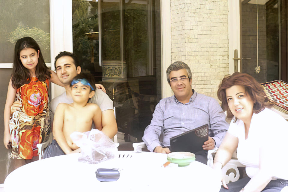 This image provided by Amir Hekmati shows Hekmati and his extended family in Tehran, Iran, in August 2011. A former U.S. Marine freed from Iranian custody five years ago is in court with the American government over whether he can collect a multimillion-dollar payment from a special fund for victims of international terrorism. Newly filed court documents show that the FBI opened an investigation into Hekmati, on suspicions that he went to Iran to sell classified information to the regime. He vigorously disputes those allegations. (Amir Hekmati via AP)