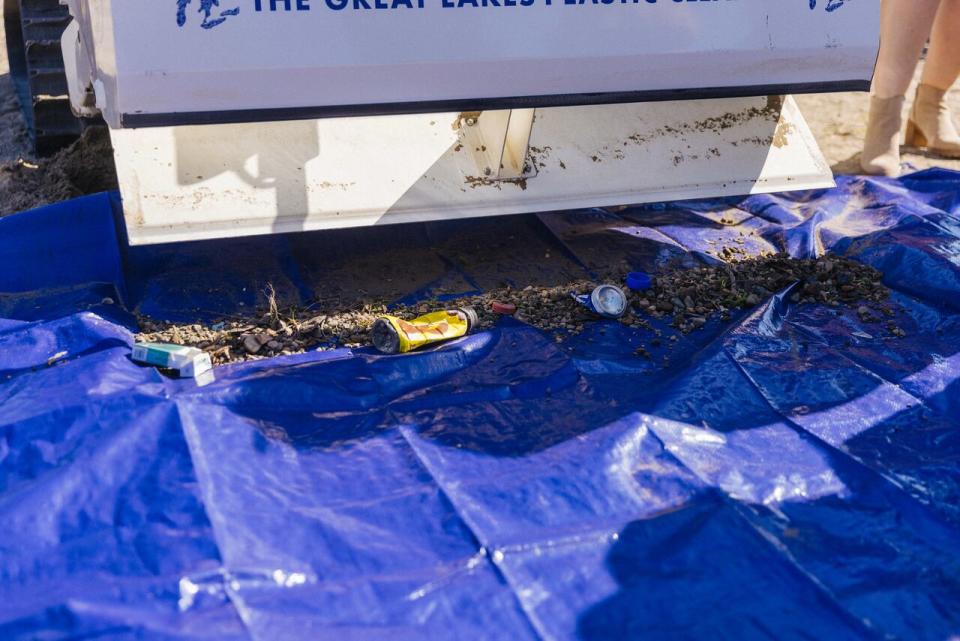 Garbage, including recyclables like plastic, is scraped from Belle Isle Beach, Mich.