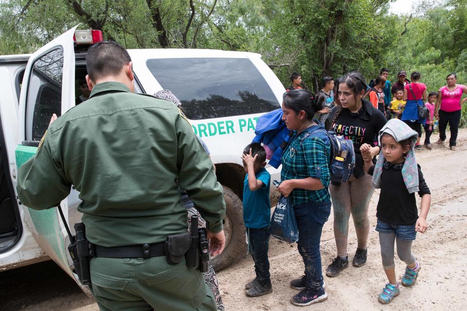 Border Patrol agents take a group of migrant families to a safer place to be transported after intercepting them near McAllen.