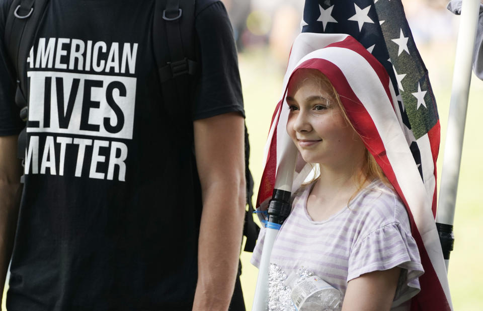 A your girl wears a flag over her head during a rally near the U.S. Capitol in Washington, Saturday, Sept. 18, 2021. The rally was planned by allies of former President Donald Trump and aimed at supporting the so-called "political prisoners" of the Jan. 6 insurrection at the U.S. Capitol. (AP Photo/Alex Brandon)