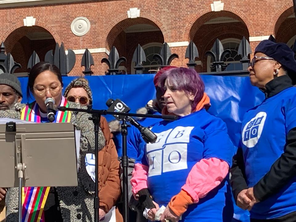 Rev. Lydia Shiu, of the Reservoir Church Cambridge, flanked by activists including Arlene Hill, right, exhorts Massachusetts leaders to address the housing crisis and increase the budget for running the 43,000 state-owned public housing units.