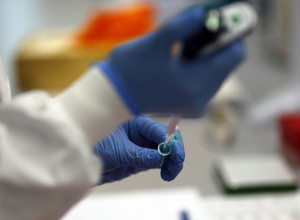 A lab assistant uses a pipette to prepare Coronavirus RNA for sequencing at the Wellcome Sanger Institute that is operated by Genome Research in Cambridge, Thursday, March 4, 2021. Cambridge University microbiologist Sharon Peacock understood that genomic sequencing would be crucial in tracking the coronavirus, controlling outbreaks and developing vaccines, so she began working with colleagues around the country to put together a plan when there were just 84 confirmed cases in the country. The initiative helped make Britain a world leader in rapidly analyzing the genetic material from large numbers of COVID-19 infections, generating more than 40% of the genomic sequences identified to date.(AP Photo/Frank Augstein)