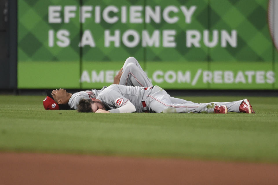 Cincinnati Reds center fielder Tyler Naquin and shortstop Jose Barrero lie on the grass after colliding during the sixth inning of a baseball game against the St. Louis Cardinals on Saturday, Sept. 11, 2021, in St. Louis. (AP Photo/Joe Puetz)