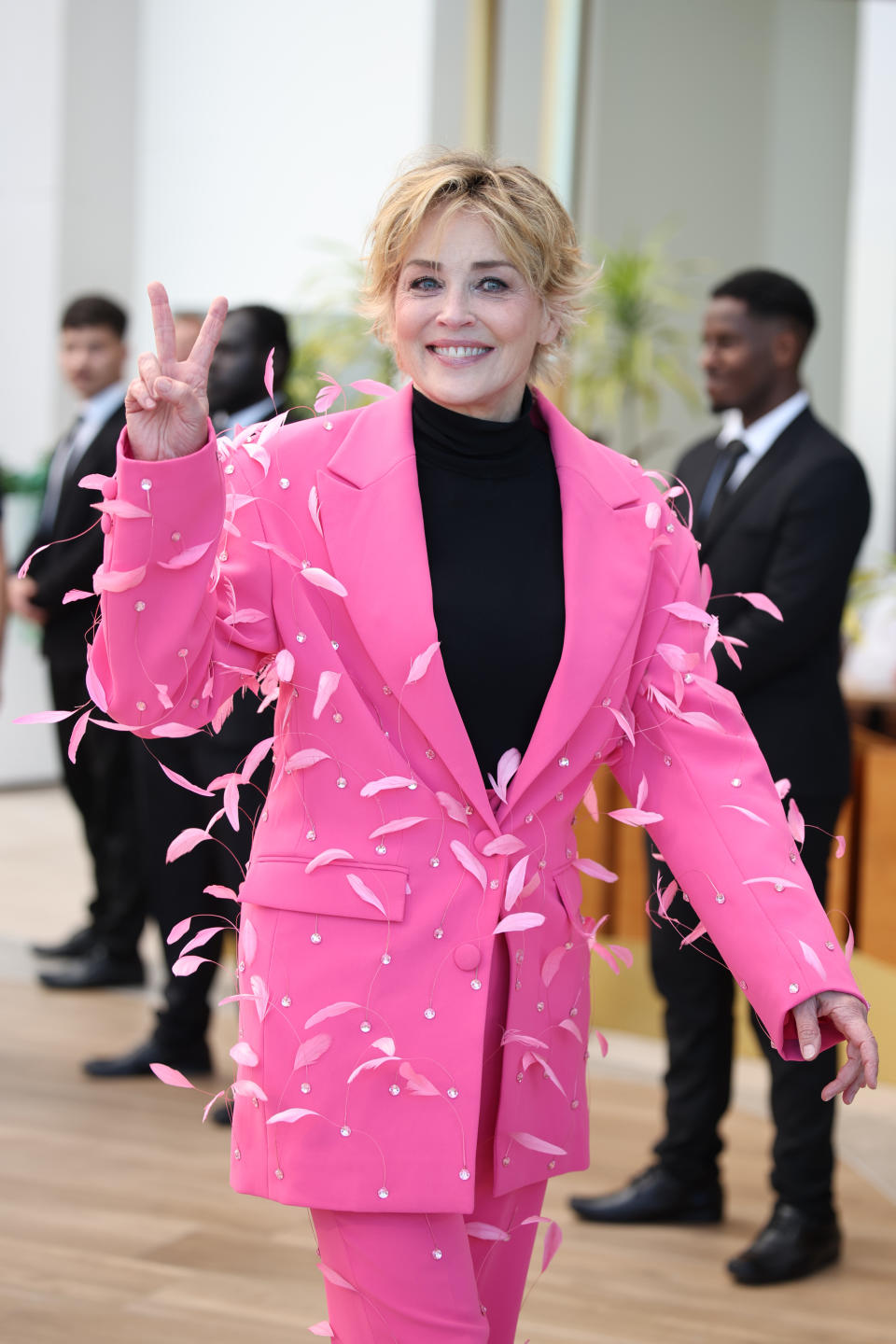 Sharon Stone wears a pink suit jacket with embellished feathers. (Getty)