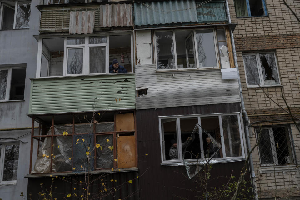 Residents remove debris from a damaged building the day after a Russian attack in Kherson, southern Ukraine, Friday, Nov. 25, 2022. A barrage of missiles struck the recently liberated city of Kherson for the second day Friday in a marked escalation of attacks since Russia withdrew from the city two weeks ago following an eight-month occupation. (AP Photo/Bernat Armangue)