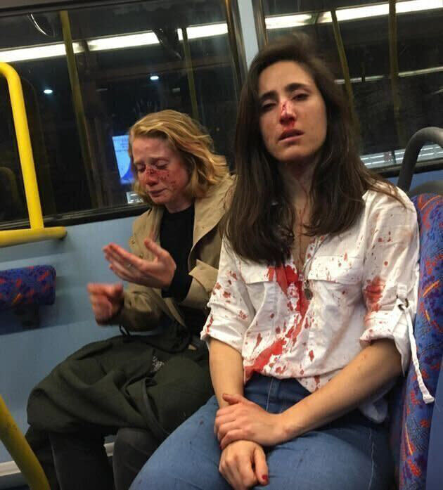 Melania Geymonat (right) and her girlfriend Chris sitting on a bus, covered in blood after the horrific attack.