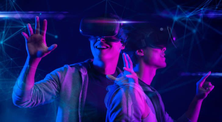 A concept image of the metaverse with two young adults wearing virtual reality headsets. undervalued metaverse stocks