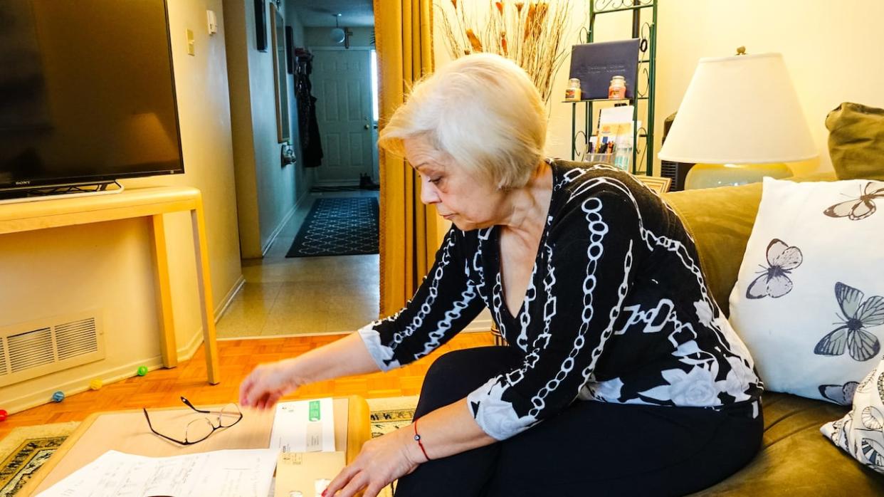 Dobrinka Gueorguieva pores over bank and pension information at her home in Ottawa's Hunt Club neighbourhood. (Stu Mills/CBC - image credit)