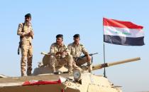 Iraqi army forces guard at the entrance of Umm Qasr Port as protesters block the road during ongoing anti-government protests, south of Basra