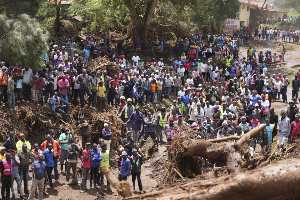 People gather on a bridge where a woman's body was retrieved, after floodwater washed away houses, in Kamuchiri Village Mai Mahiu, Nakuru County, Kenya, Tuesday, April 30, 2024. Kenya, along with other parts of East Africa, has been overwhelmed by flooding that killed 66 people on Monday alone and in recent days has blocked a national highway, swamped the main airport and swept a bus off a bridge. More than 150,000 people are displaced and living in dozens of camps. (AP Photo/Brian Inganga)