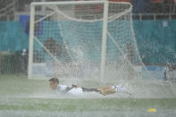 Austria's Christoph Baumgartner takes a dive on the pitch during a heavy rainfall before a training session at the National Arena stadium in Bucharest, Romania, Saturday, June 12, 2021, the day before their first match against North Macedonia. (AP Photo/Vadim Ghirda)