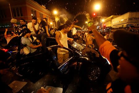 Revellers celebrate from a moving vehicle in San Francisco, California October 29, 2014. REUTERS/Stephen Lam