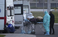 Medical workers carry a patient suspected of having coronavirus on a stretcher at a hospital in Kommunarka, outside Moscow, Russia, Monday, Oct. 11, 2021. Russia's daily coronavirus infections and deaths are hovering near all-time highs amid a laggard vaccination rate and the Kremlin's reluctance to toughen restrictions. Russia's state coronavirus task force reported 29,409 new confirmed cases Monday. That's the highest number since the start of the year and just slightly lower than the pandemic record reached in December. (AP Photo/Alexander Zemlianichenko)