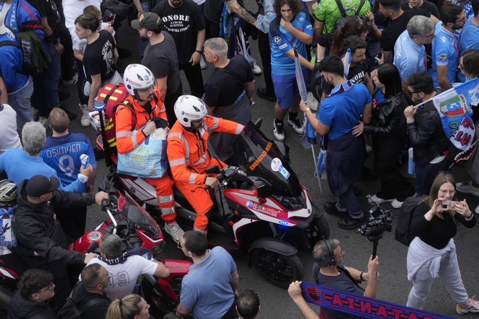 Paramedics drive through a crowd of fans outside the stadium for the Serie A soccer match between Napoli and Salernitana at the Diego Armando Maradona stadium, in Naples, Italy, Sunday, April 30, 2023. (AP Photo/Gregorio Borgia)