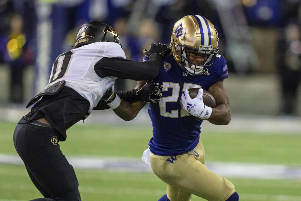 Washington running back Cameron Davis tries to get past Colorado defensive back Kaylin Moore during the first half of an NCAA college football game Saturday, Nov. 19, 2022, in Seattle. (AP Photo/Stephen Brashear)