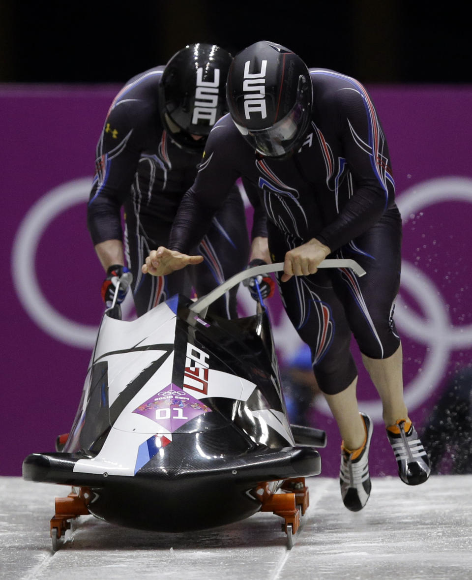 The team from the United States USA-1, piloted by Steven Holcomb and brakeman Steven Langton, start their first run during the men's two-man bobsled competition at the 2014 Winter Olympics, Sunday, Feb. 16, 2014, in Krasnaya Polyana, Russia. (AP Photo/Dita Alangkara)