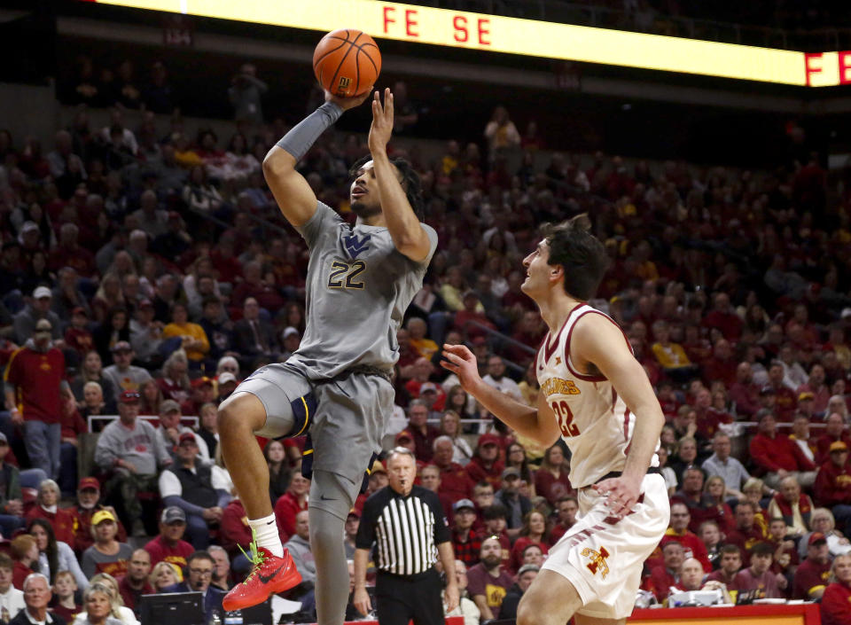 West Virginia forward Josiah Harris, left, drives to the basket ahead of the defense of Iowa State forward Milan Momcilovic during an NCAA college basketball game, Saturday, Feb. 24, 2024, in Ames, Iowa. (AP Photo/Bryon Houlgrave)
