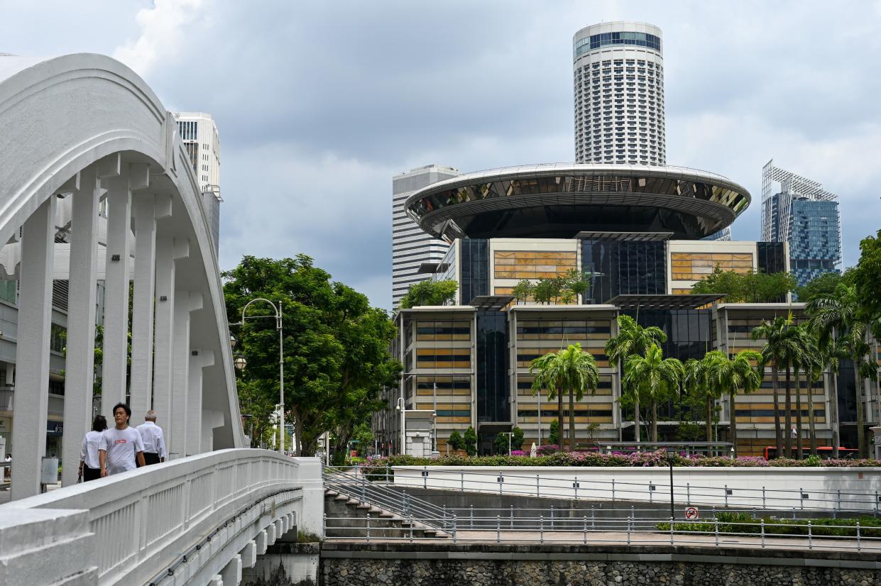 People walk across a bridge near the Supreme Court (R) in Singapore on November 9, 2021. (Photo by Roslan RAHMAN / AFP) (Photo by ROSLAN RAHMAN/AFP via Getty Images)