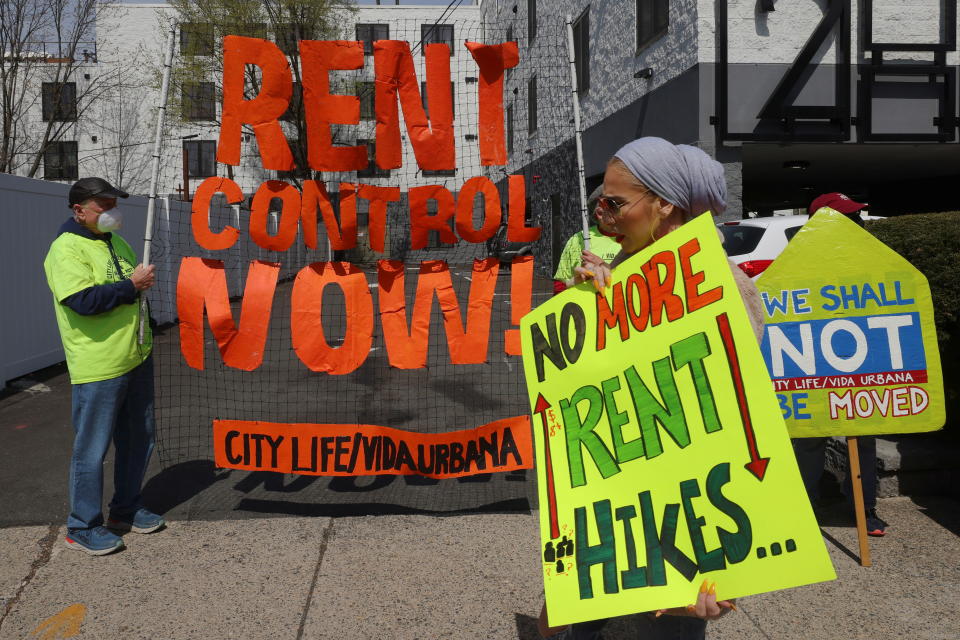 Housing rights activists and tenants protest, carrying signs and pickets saying: No More Rent Hikes; We Shall NOT Be Moved and Rent Control Now! City Life/Vida Urbana.  