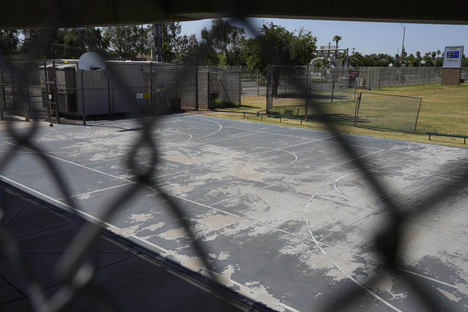 A maintenance crew member at a Phoenix elementary school discovered the body of 60-year-old transient Ronald Rogers in a shaded outdoor area where he evidently crawled after climbing over a 10-foot (3-meter) fence, breaking both legs in a jump or fall, shown here, Thursday, May 9, 2024, in Phoenix. County authorities never found his next of kin. Rogers was later interred in Maricopa County's White Tanks Cemetery, where the county's dead are laid to rest if they they have no known family. (AP Photo/Ross D. Franklin)