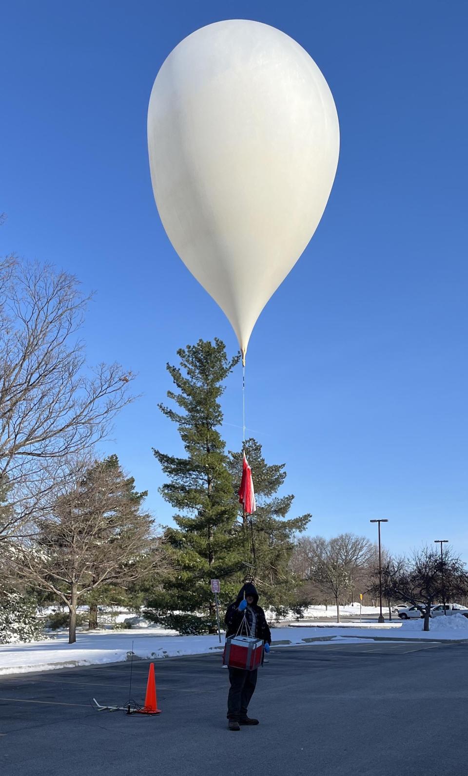 Kellan French, a senior in aerospace engineering, prepares to launch the fully inflated balloon.