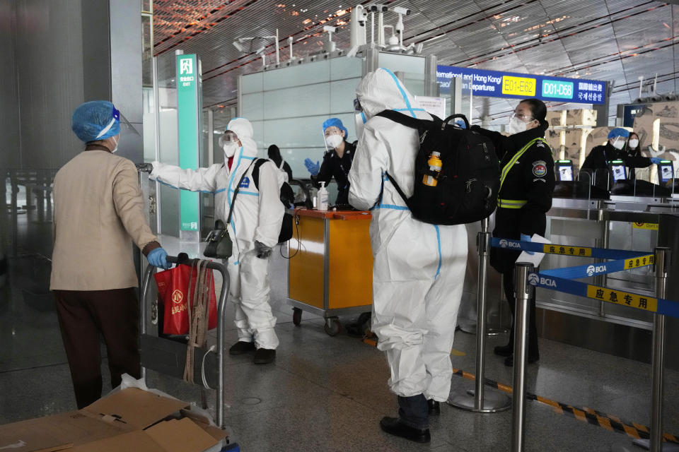 FILE - Passengers in protective gear are directed to a flight at a Capital airport terminal in Beijing on Dec. 13, 2022. Companies welcomed China’s decision to end quarantines for travelers from abroad as an important step to revive slumping business activity while Japan on Tuesday, Dec. 27, announced restrictions on visitors from the country as infections surge. (AP Photo/Ng Han Guan, File)