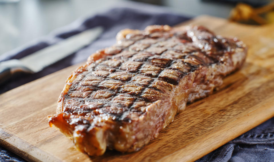 A piece of meat resting on a cutting board.