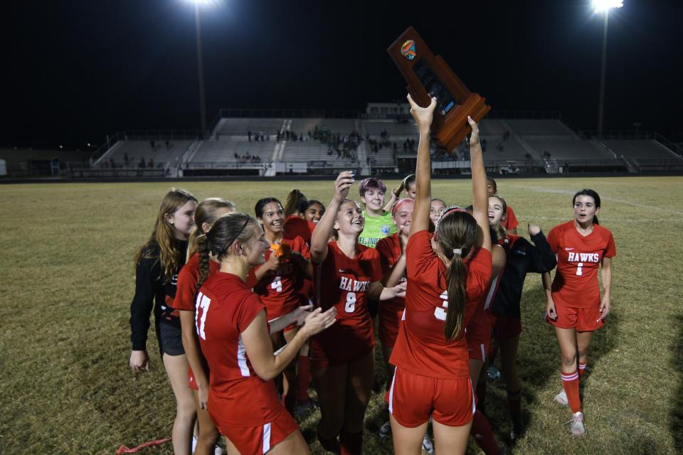 The Seminole Ridge girls soccer team holds the district title trophy in celebration following their 1-0 overtime win against Dwyer on Feb. 1, 2023.