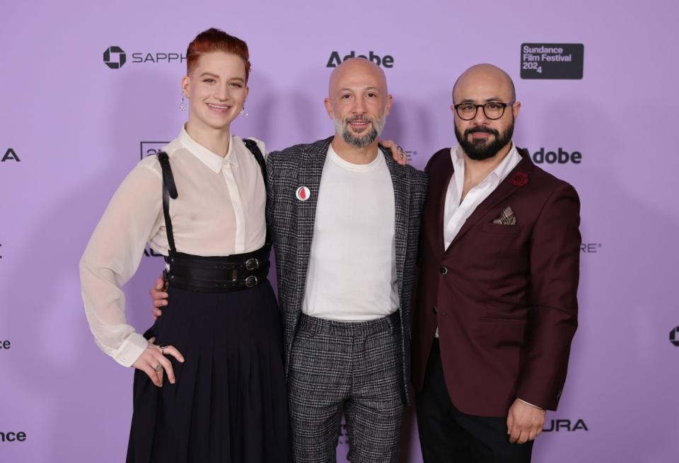 Theo Germaine, Director Jules Rosskam and Aden Hakimi  pose for a photo in front of a step and repeat at the Sundance Film Festival