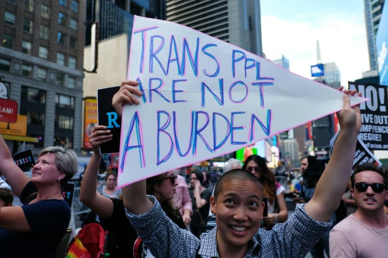 Protesters display placards against US President Donald Trump during a demonstration in front of the US Army career center in Times Square, New York, in 2017