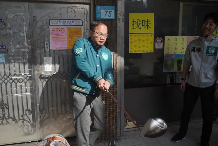 民進黨不分區立委參選人王義川陪吳崢掃街還帶高爾夫球桿。吳崢辦公室提供