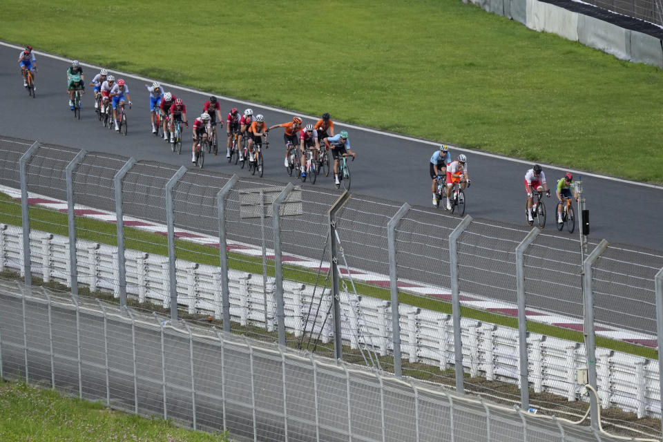 Athletes compete during the men's cycling road race at the 2020 Summer Olympics, Saturday, July 24, 2021, in Oyama, Japan. (AP Photo/Christophe Ena)