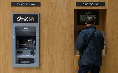 A man uses an ATM inside Coutts private bank in London, Britain October 10, 2017. REUTERS/Peter Nicholls/Files