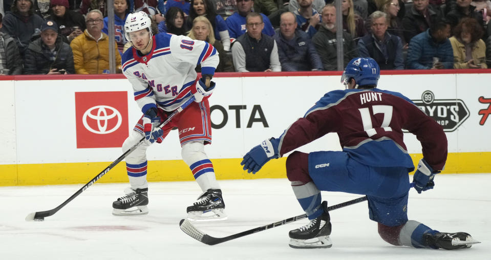 New York Rangers left wing Artemi Panarin, left, looks to pass the puck as Colorado Avalanche defenseman Brad Hunt, right, covers in the second period of an NHL hockey game Friday, Dec. 9, 2022, in Denver. (AP Photo/David Zalubowski)