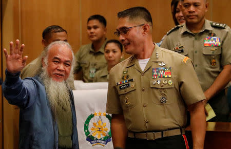 Marawi's vicar-general Father Teresito "Chito" Soganub waves to the media and soldiers at a military camp, after soldiers rescued him from the Islamic State-linked rebels stronghold in Marawi, during a news conference in Quezon City, Metro Manila, Philippines September 18, 2017. REUTERS/Dondi Tawatao