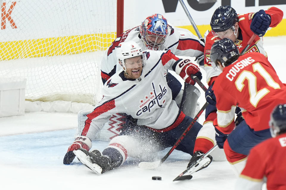 Washington Capitals defenseman Nick Jensen (3) and goaltender Charlie Lindgren (79) stop a shot from Florida Panthers centers Nick Cousins (21) and Evan Rodrigues (17) during the third period of an NHL hockey game, Saturday, Feb. 24, 2024, in Sunrise, Fla. (AP Photo/Wilfredo Lee)