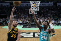 Golden State Warriors guard Stephen Curry shoots over Charlotte Hornets forward Brandon Miller shoots over during the first half of an NBA basketball game on Friday, March 29, 2024, in Charlotte, N.C. (AP Photo/Chris Carlson)