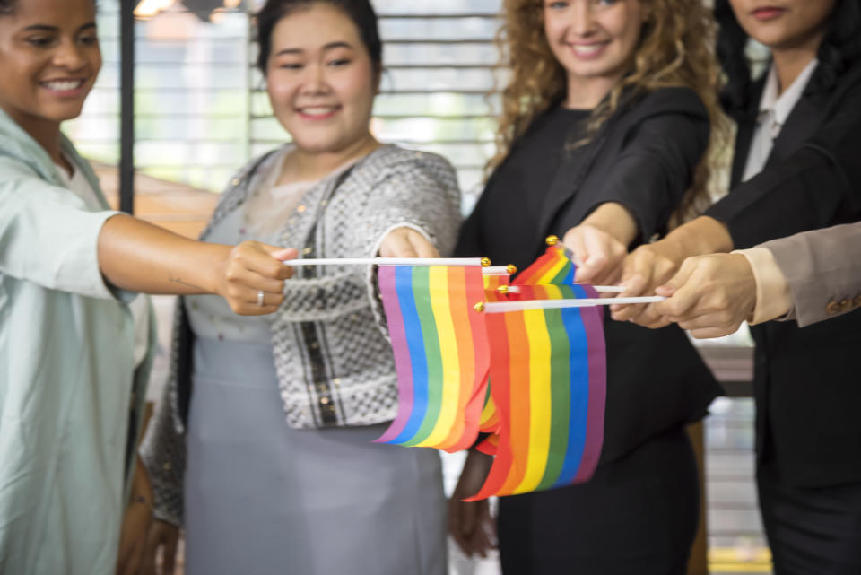 office workers holding rainbow flags