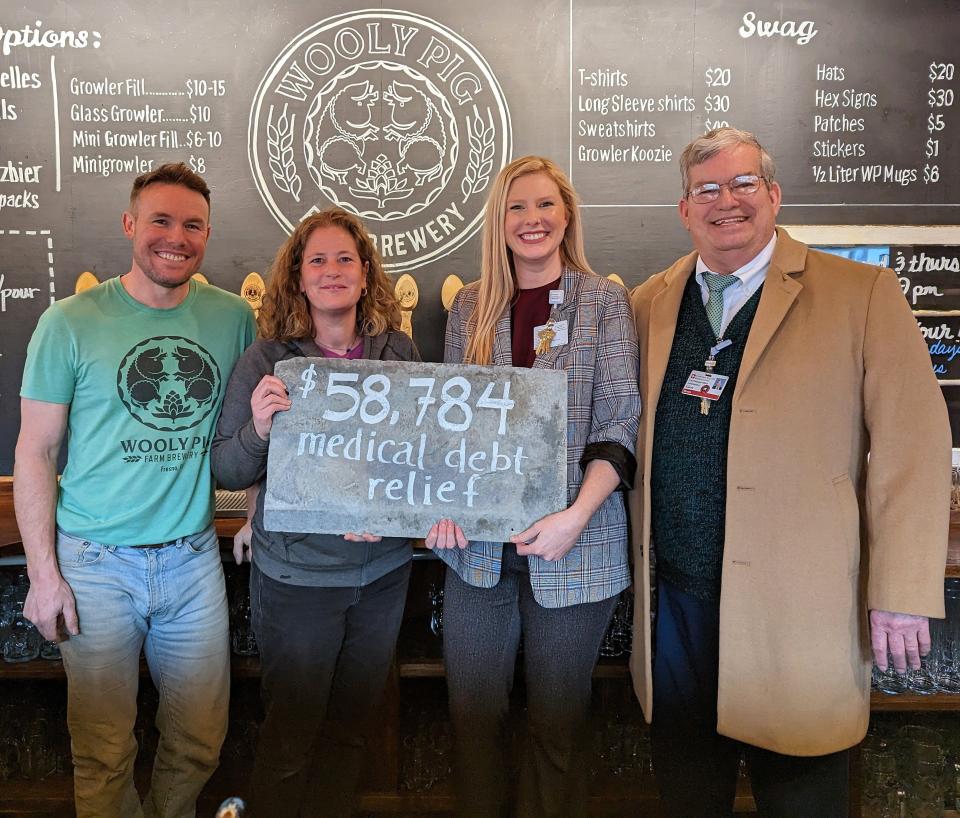 Kevin Ely and Jael Malenke, owners of the Wooly Pig Farm Brewery, with Kaylee Andrews, director of business development and marketing, and Gerry Breen, CFO, of Coshocton Regional Medical Center are shown as donation of $8,784 by the brewery was given to the hospital to help forgive medical debts.