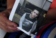 Kalthoum Helel holds a picture of her son Ghofrane Helel, in Ras Jebel, near Bizerte, Tunisia, Wednesday Sept.23, 2020. Helel fears her son Ghofrane who left Tunisia for Italy last September at the age of 20 was lost at sea. The number of Tunisians migrating clandestinely to Italy has risen to levels not seen since the 2011 Arab Spring uprising. That's causing tensions in Italy's south, where more than 2,200 migrants are quarantining on ferries anchored offshore. (AP Photo/Hassene Dridi)