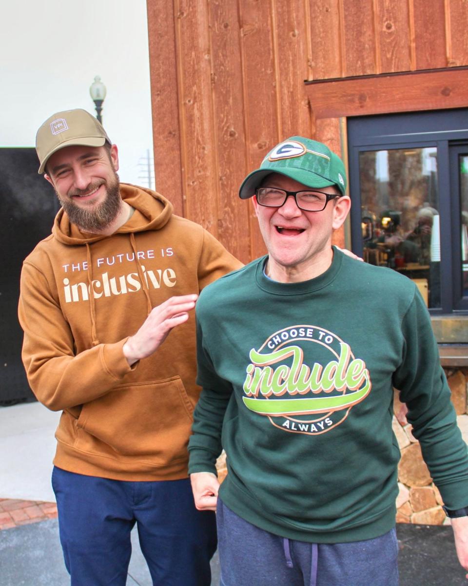 Matt, former VPI Community Inclusion Manager, wears a “The Future is Inclusive” hoodie and Paul, VPI pre-employment client wears a “Choose to Include” crewneck from the Inclusion Clothing Co during a photo shoot outside Globe Coffee in Neenah.