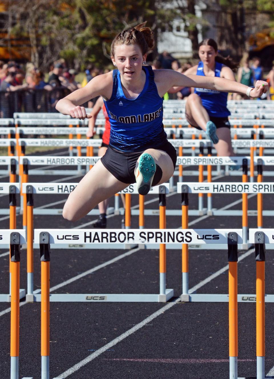 Mackinaw City senior and Inland Lakes athlete Larissa Huffman clears a hurdle in the 100 meter event, which she won. Huffman was also second in the high jump.